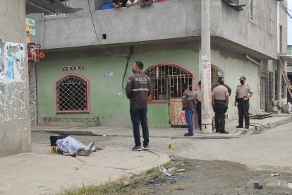 La víctima yace cubierta con una sábana. Agentes de la Policía se hicieron presentes luego del asesinato.