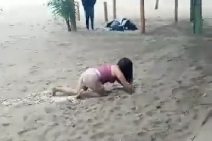 Una  mujer en aparente estado etílico se arrastraba por la playa en Montañita.