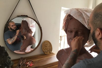 Miguel explica cómo se debe ir modelando la imagen de la persona en la escultura.