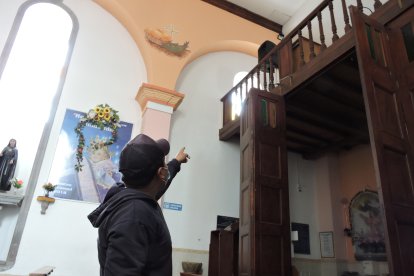 Uno de los  trabajadores del templo muestra la ventana por la que entraron los ladrones.