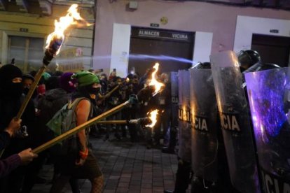 Manifestantes que conmemoraban el 8M, frente a una fuerte barrera policial en Quito.