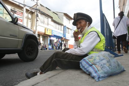 Por su edad, este hombre se sienta en la vereda y desde ahí intenta dirigir a los choferes.