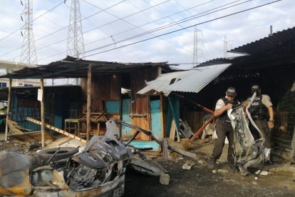 Dos agentes de la Policía verifican los daños ocasionados por la explosión.