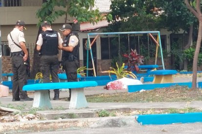 Agentes de la Policía junto al cadáver de Israel Alexander Vizuete Quiñónez, de 23 años.