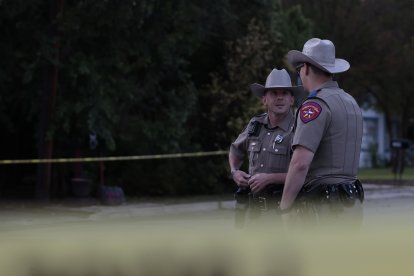 Olicías e investigadores continúan trabajando en la escena del tiroteo.