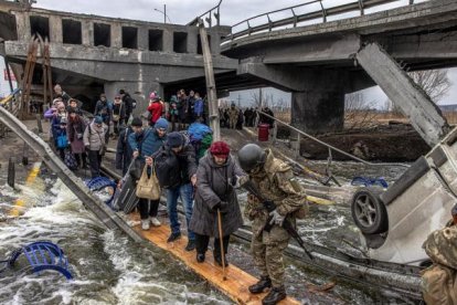 Decenas de civiles cruzaban por un puente semi destruido por los ataques rusos en el ciudad de Irpin,en la región ucraniana de Kiev, el pasado mes de marzo.