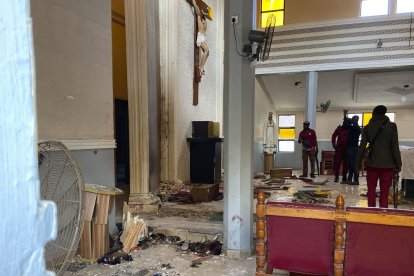 Personas miran los daños ocasionados por los ataques a una iglesia, donde murió medio centenar de personas.