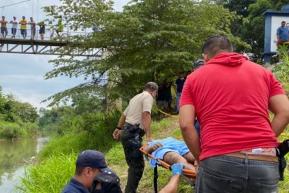 Policías y bomberos en pleno rescate del cuerpo del hombre.