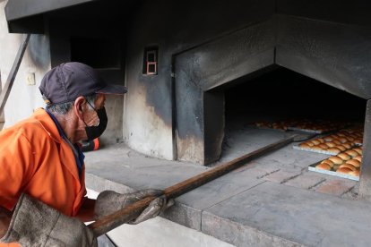 José Ortiz, un elaborador de "cholas", trabaja en el horneado de los panes, el 9 de junio de 2022, en Guano (Ecuador).
