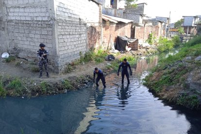 Agentes del GIR buscaron en una zanja de la vía a Daule las evidencias que habrían sido arrojadas en este canal de agua.