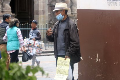 El hombre pide dinero en el centro de Quito.
