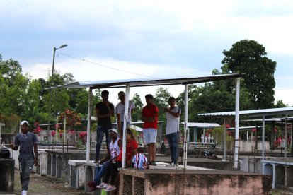 Algunos prefieren ubicarse sobre las tumbas del cementerio que está a un costado de la cancha para alentar a sus equipos.