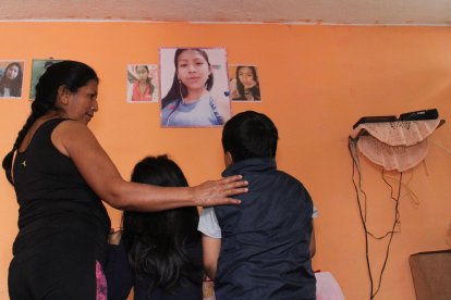 Carmen cuida a sus dos nietos, de 7 y 5 años; de fondo, colgado en la pared, está el retrato de Solange Tituaña, asesinada el 7 de abril de 2020.