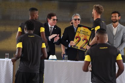 Javier Burrai, estrenando su arete, le entrega la camiseta de Barcelona al presidente Lasso.