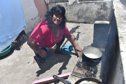 Irene prepara sus  alimentos en una cocina de leña, en la terraza de una casa prestada.