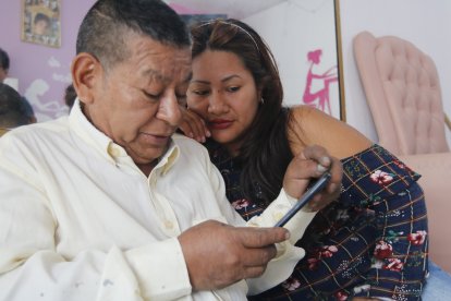 Los parientes de Janeth German miran las imágenes de la joven en su celular.