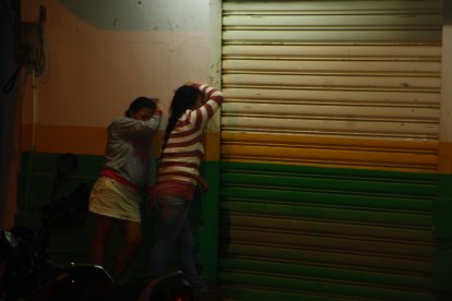 Los familiares del asesinado lloran al pie de la farmacia donde ocurrió el crimen.