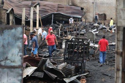 Trabajadores buscaban entre los escombros algún objeto que no haya sido contaminado.
