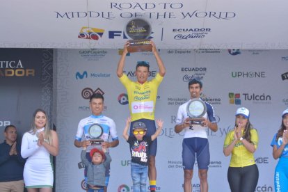 El ciclista colombiano Robinson Chalapud (c) con el maillot  amarillo y el trofeo como campeón de la Vuelta al Ecuador.