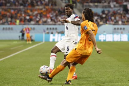 Nathan Ake (d) de Países Bajos disputa un balón con Yunus Musah de Estados Unidos hoy, en un partido de los octavos de final del Mundial de Fútbol Qatar 2022 entre Países Bajos y Estados Unidos en el estadio Internacional Jalifa en Doha (Catar).