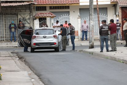 El cuerpo del policía Johann Vinueza fue sacado de su auto y subido en carro de Medicina Legal.