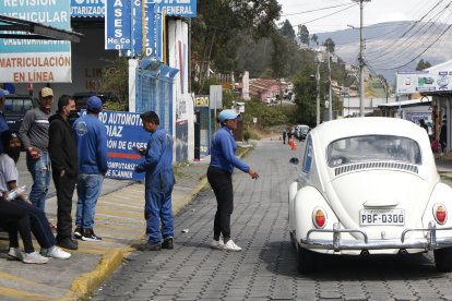Una mujer anuncia a viva voz los servicios que ofrece un taller.