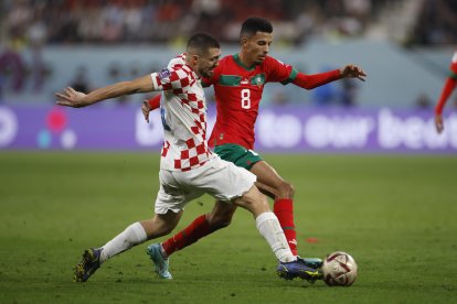 Mateo Kovačić (i) de Croacia disputa un balón con Azzedine Ounahi de Marruecos hoy, en un partido por el tercer lugar del Mundial de Fútbol Qatar 2022 entre Croacia y Marruecos en el estadio Internacional Jalifa en Rayán (Catar).