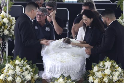 Marcia Aoki (d) junto al ataúd de su esposo Pelé. La familia decidió que el velorio del astro brasileño se realice con féretro abierto.