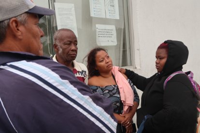 Karen Plúas (centro) presenció el crimen de su esposo y padre de sus hijos. Sus familiares le dan consuelo.