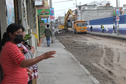 Ante la falta de movimiento en sus tiendas, los vecinos salen a la calle para mirar el avance de la obra.