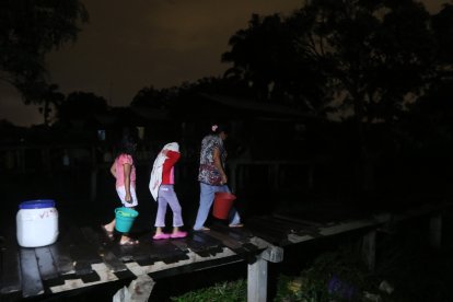 Una comunera y dos niños regresaban con agua a su vivienda debido a la falta  del líquido potable en las edificaciones.