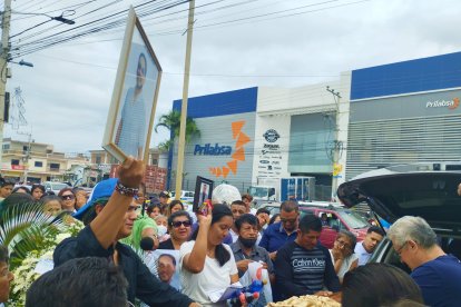 El hijo del fallecido levantó una foto de su padre mientras lo metían en un auto.