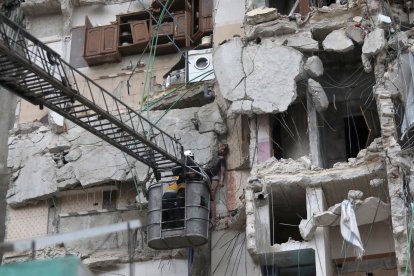 Un rescatista localiza a una persona entre los escombros de un edificio tras un terremoto en la provincia de Idlib, Siria.