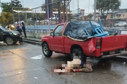 El cuerpo de Carlos Augusto Ramírez Vera quedó doblado de espalda, junto a una camioneta roja.