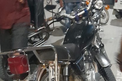 Agentes investigan detalles de la motocicleta color negra que estaba a lado de cadáver.