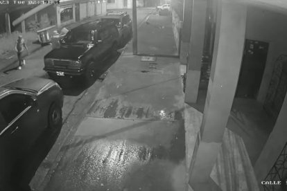 Momento en el que dos sujetos se acercan para arrojar un líquido sobre el carro.