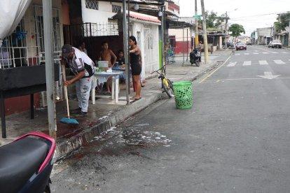 Moradores limpian la sangre que se derramó en la balacera.