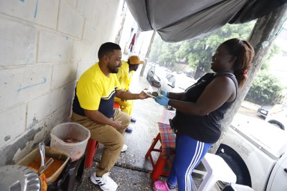 Julia Nazareno atendió a sus clientes con normalidad junto a su sobrino Gilbert, a pesar de la fuerte lluvia.