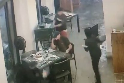 Momento en que el sujeto que estaba solo se acerca a dos ciudadanos para dispararles.