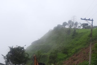 En el sitio se encuentra maquinaria realizando labores de limpieza con el fin de rehabilitar la carretera que une a Guayas con Cañar y Azuay.
