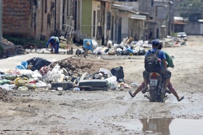 Los conductores y transeúntes deben sortear los baches llenos de agua y los ‘cerros’ de basura.