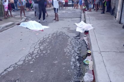 Los cuerpos de Pedro Guerrero Ulloa (izquierda) y Tulio Jefferson Corozo quedaron sobre la calzada. Fueron cubiertos con una sábana.