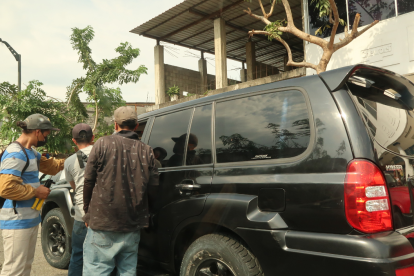 Las personas se aglomeran cerca de los vehículos en la calle Ayacucho