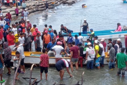 Personas que se encontraban en la orilla se acercaron a la lancha en la que quedaron los cuerpos de los fallecidos.