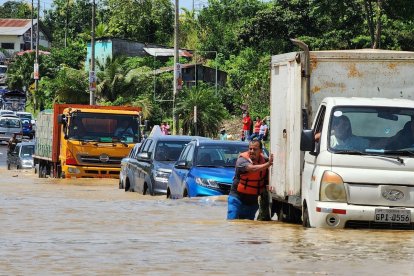 Conductores de los vehículos altos se arriesgaron a pasar por la carretera inundada.