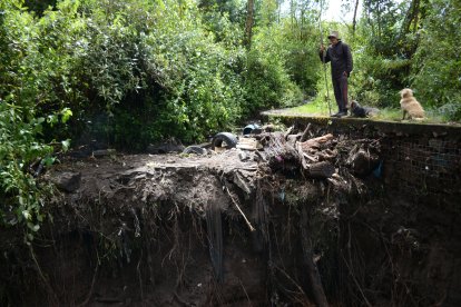 Javier Simbaña muestra la basura y llantas que quedaron luego del desbordamiento.