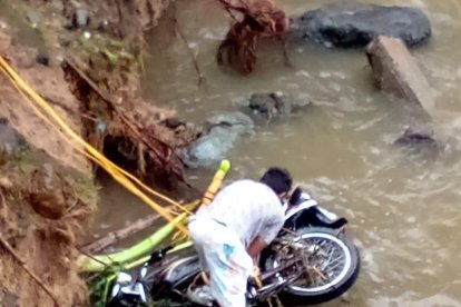 Con unos cabos, un morador trataba de amarrar el liviano vehículo y sacarlo del estero en el que supuestamente cayó Leonardo.