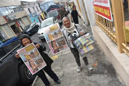 Dos voceadores  muestran con alegría el Diario EXTRA que venden todos los días en Quito.