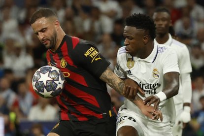 MADRID, 09/05/2023.- El defensa del Manchester City Kyle Walker (i) lucha con Vinicius Jr., del Real Madrid, durante el partido de ida de las semifinales de la Liga de Campeones que Real Madrid y Manchester City disputan este martes en el estadio Santiago Bernabéu, en Madrid. EFE/Juanjo Martín