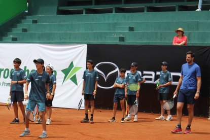 El tenista argentino Juan Martín del Potro (d) durante la clínica con pequeños tenistas